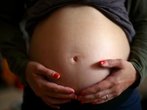 A pregnant woman holding her stomach