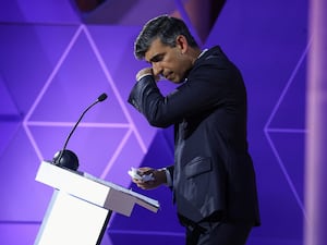 Rishi Sunak looks down and wipes his face with his hand during a televised debate with Sir Keir Starmer