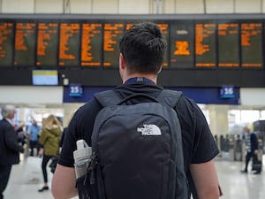 Someone looks at a rail timetable board