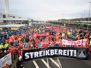 Volkswagen workers march holding a sign with writing reading in German “Ready to Strike!”