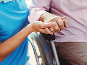 Nurse consoling an elderly woman in a nursing home