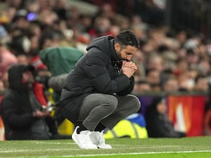 Ruben Amorim crouches down on the touchline