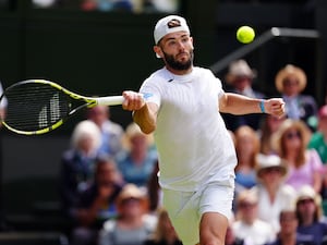 Jacob Fearnley strikes a forehand during his match against Novak Djokovic at Wimbledon