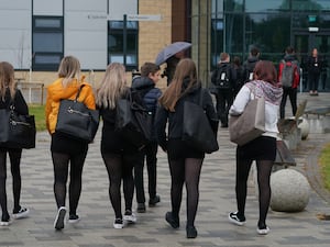 Pupils walking in a line towards a school