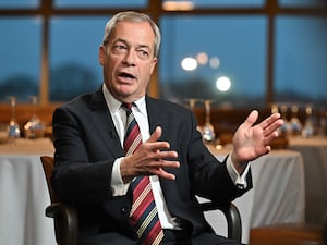 Nigel Farage gesturing with both arms while speaking