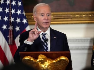 Joe Biden at a lectern before the stars and stripes