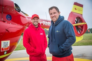 Crew modelling the charity's branded red cap and blue hoodie.