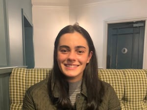 Jenny Hall sitting on a sofa and smiling