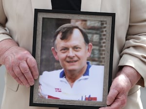 Bridie Brown, the widow of murdered GAA official Sean Brown, holds a picture of him (PA)