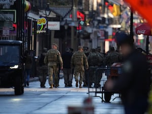 Military personnel walk down Bourbon street