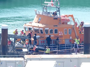 People disembarking an RNLI boat at a harbour