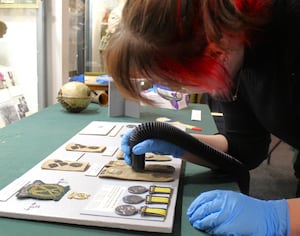 Volunteer Eve cleans textiles with a conservation hoover 