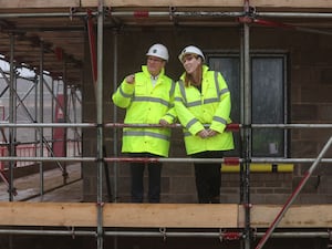 Sir Keir Starmer and Angela Rayner in hi-viz jackets and hard hats, beside a property under construction