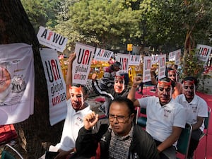 People wear masks of Amazon’s Jeff Bezos during a protest in New Delhi, India