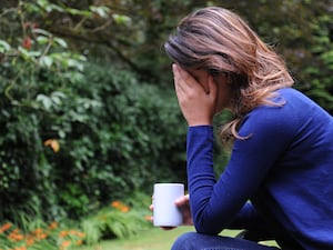 A woman sits with her head in her hands