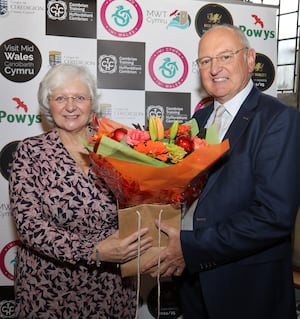 MWT Cymru chairman Rowland Rees-Evans presents the bouquet and gift to Val Hawkins, MBE, to thank her for her service to the company.