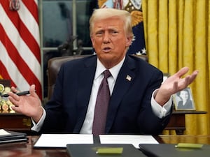 Donald Trump sitting behind the desk in the Oval Office