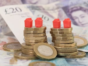 Model houses on a stack of coins