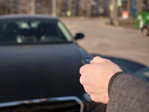 A man uses a remote key fob to open his car