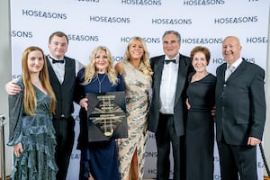 Cosmo Lloyd (third from right) and Keeta Thomas (third from left), Joint Owners of Henlle Hall Woodland Lodges and members of the team receive the park’s award from Gemma Brown, General Manager at Hoseasons  