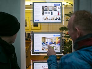 People looking in an estate agent's window