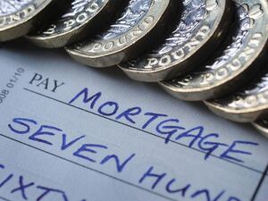 A mortgage note surrounded by pound coins