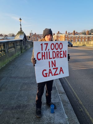 People stood on the bridge with different signs highlighting the ongoing crisis in Gaza