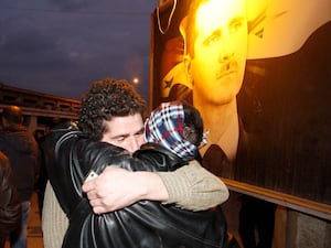 A freed Syrian prisoner, left, hugs his brother after being released from Adra Prison on the northeast outskirts of Damascus