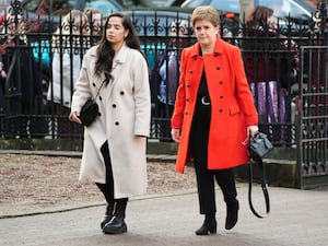 Nicola Sturgeon, in a red coat, arrives for the funeral