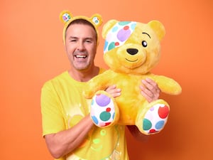 Paddy McGuinness holding up a Pudsey bear