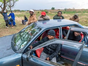 Relatives of miners and community members wait near the shaft of a closed mine where illegal miners are inside in Stilfontein, South Africa