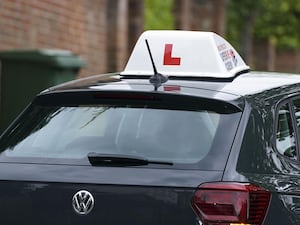 A driving instructor's car with an L sign on top