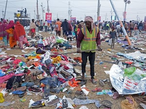 A volunteer helps people to look for their valuables after a stampede when Hindu devotees rushed to take a holy bath in the Sangam