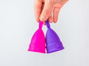 Hand holding two menstrual cups