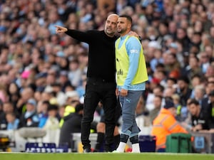 Manchester City manager Pep Guardiola speaks with substitute Kyle Walker on the touchline