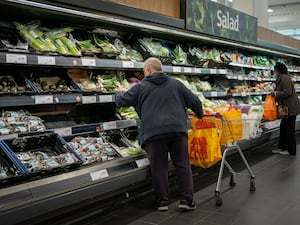 People looking at veg in a supermarket