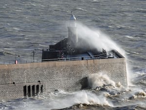 Waves crash over the harbour wall in Folkestone, Kent, on Monday