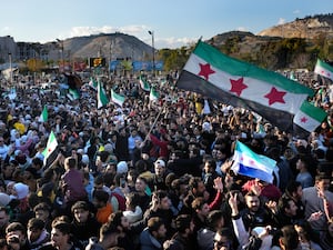 Syrians celebrate during a demonstration in Damascus’s central square