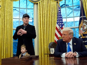 President Donald Trump listens as Elon Musk, joined by his son X Æ A-Xii, speaks in the Oval Office at the White House