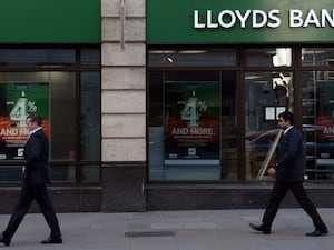 People walk past a Lloyds Bank branch