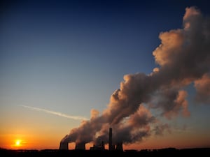 The sun setting behind a coal-fired power station