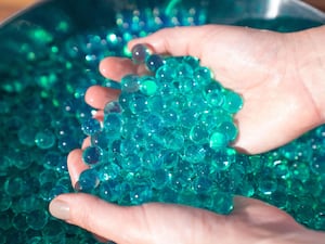 A person plays with water beads