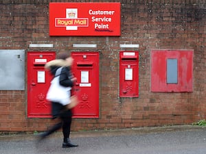 A person walking past a Royal Mail sorting office