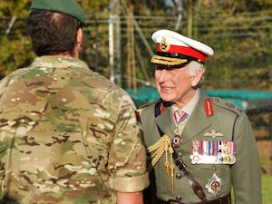 The King in uniform with a man in camouflage gear