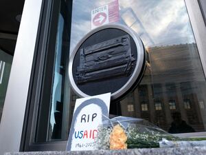 Flowers and a sign are placed outside the headquarters of the US Agency for International Development,