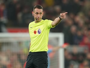 David Coote points while refereeing a game