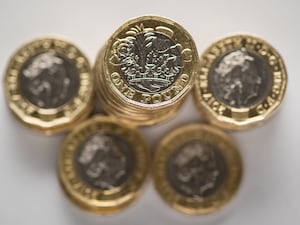 Pound coins stacked up in piles