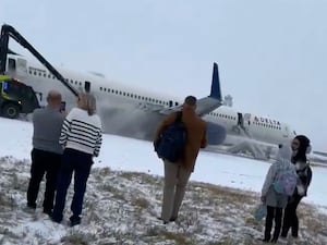 Passengers next to plane on runway