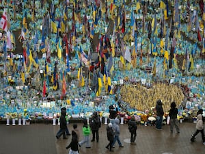 People walk past the memorial to fallen soldiers in Independence Square in Kyiv, Ukraine