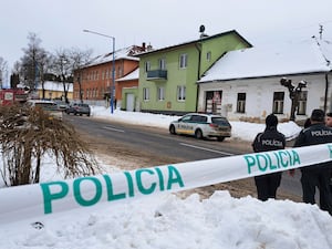 Police behind police tape in a snowy street in Slovkia